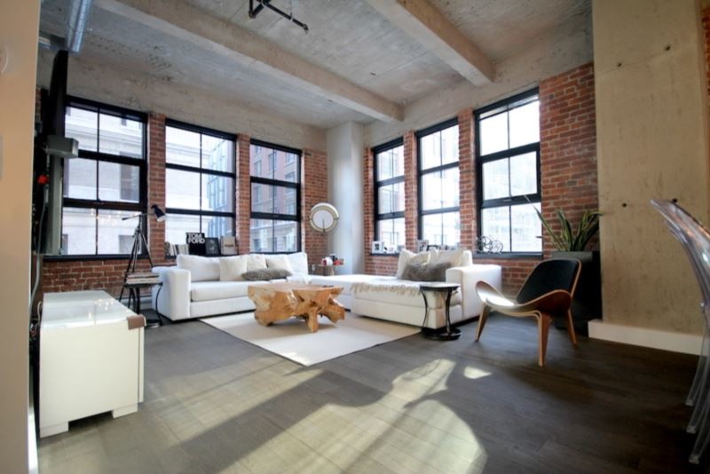 Imagen de salón para visitas tipo loft industrial grande con paredes blancas, suelo de madera oscura, televisor colgado en la pared y suelo marrón