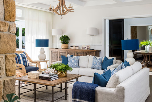 modern coastal living room featuring blue accents, wicker chairs and light furniture