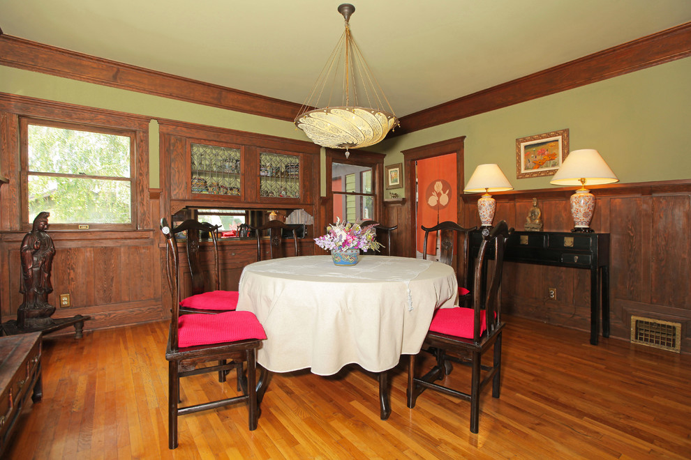 Exemple d'une salle à manger craftsman de taille moyenne avec un mur beige, parquet clair, une cheminée standard et un manteau de cheminée en brique.
