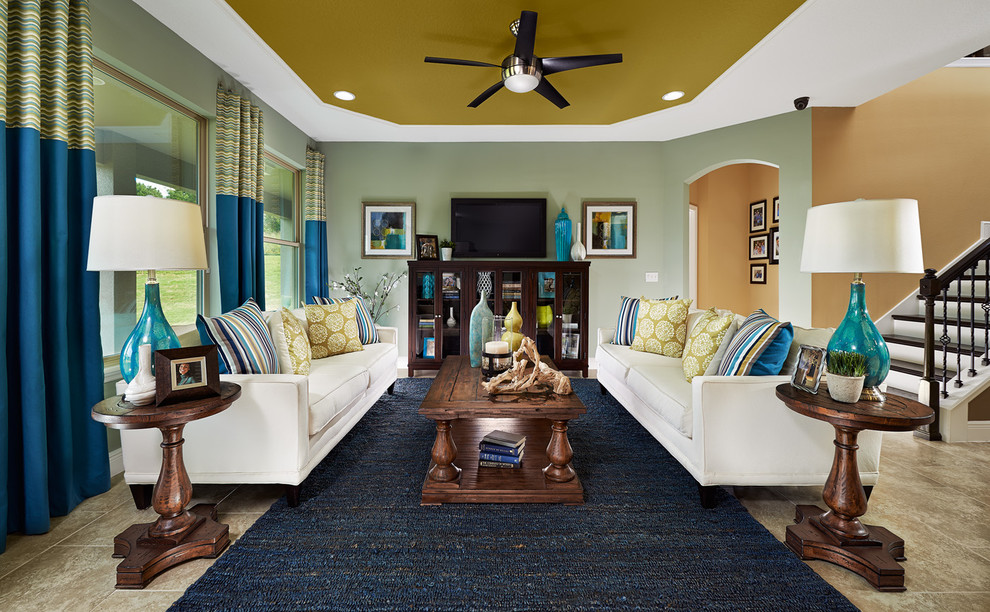Пример оригинального дизайна: открытая гостиная комната в классическом стиле с зелеными стенами, телевизором на стене и синими шторами