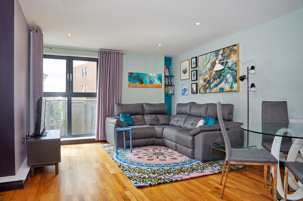 Kleines, Offenes, Repräsentatives Modernes Wohnzimmer ohne Kamin mit freistehendem TV, bunten Wänden, braunem Holzboden und gelbem Boden in London