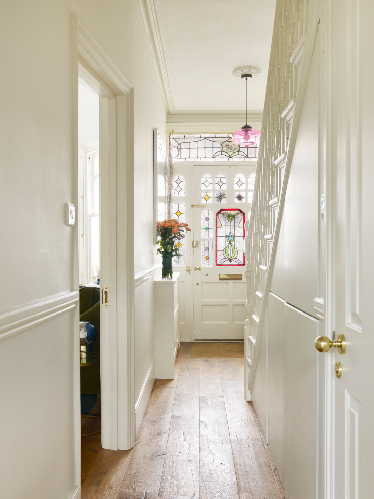 Ispirazione per un grande soggiorno tradizionale con pareti bianche, pavimento in legno massello medio e pavimento beige