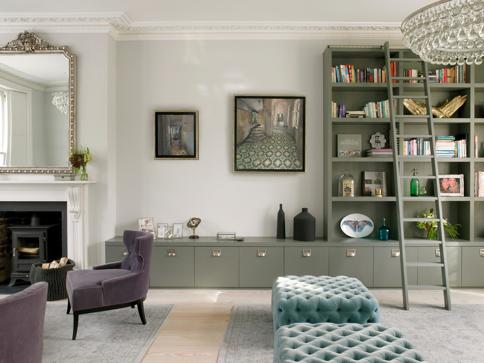 Example of a large transitional open concept light wood floor and beige floor living room design in London with gray walls, a standard fireplace, a stone fireplace and no tv