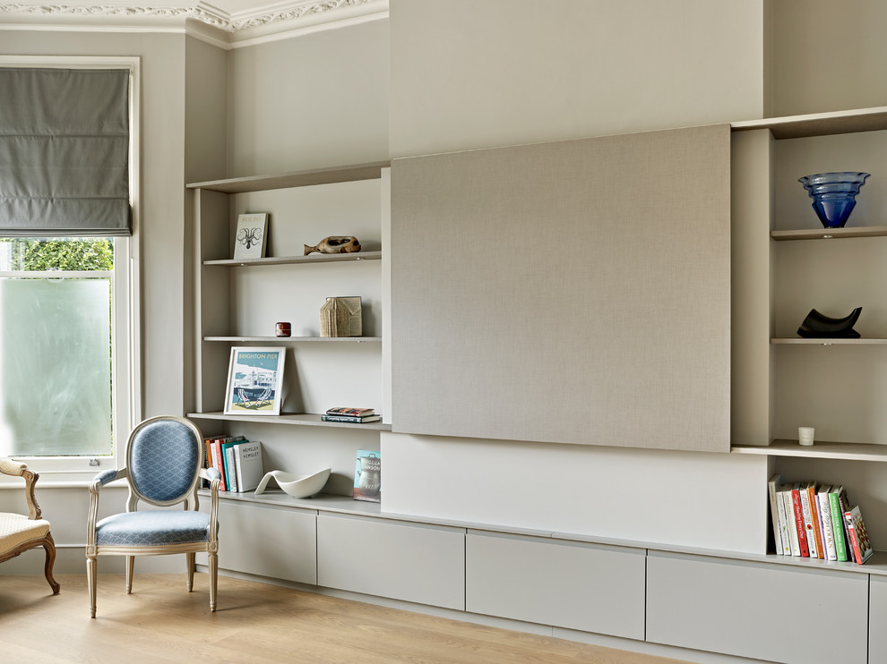 Ejemplo de salón abierto minimalista sin chimenea con paredes grises, suelo de madera clara, pared multimedia y suelo marrón