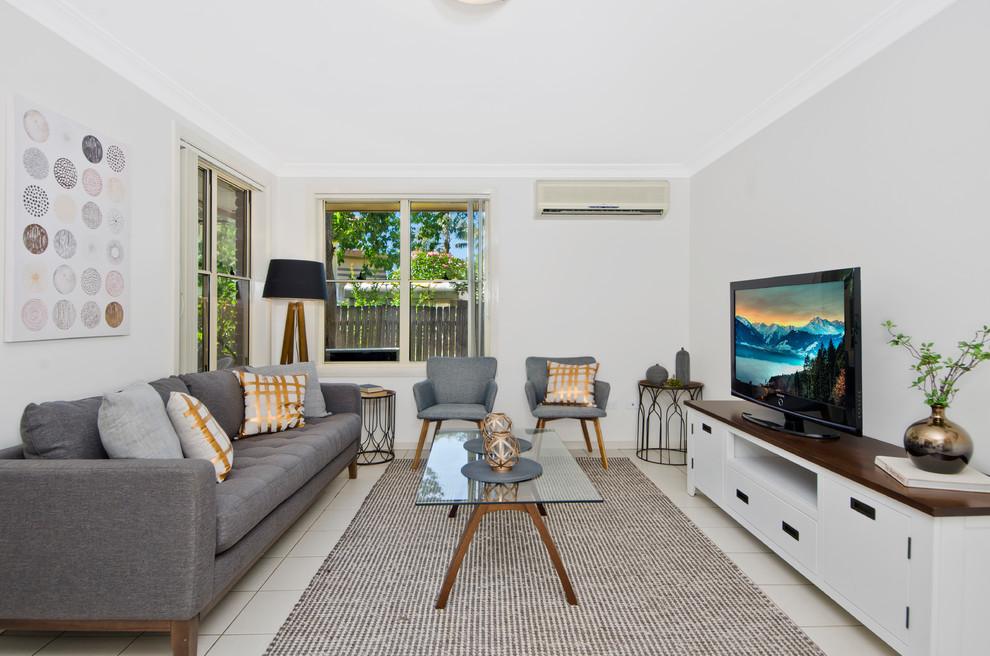 Пример оригинального дизайна: парадная, изолированная гостиная комната в стиле неоклассика (современная классика) с серыми стенами, отдельно стоящим телевизором и бежевым полом