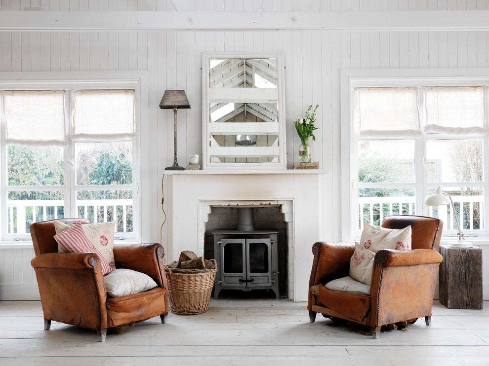 Idee per un soggiorno stile shabby con pareti bianche, parquet chiaro e stufa a legna
