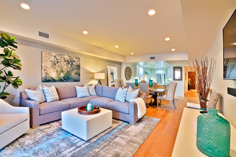 Idee per un piccolo soggiorno stile marino aperto con pareti beige, parquet chiaro e TV a parete
