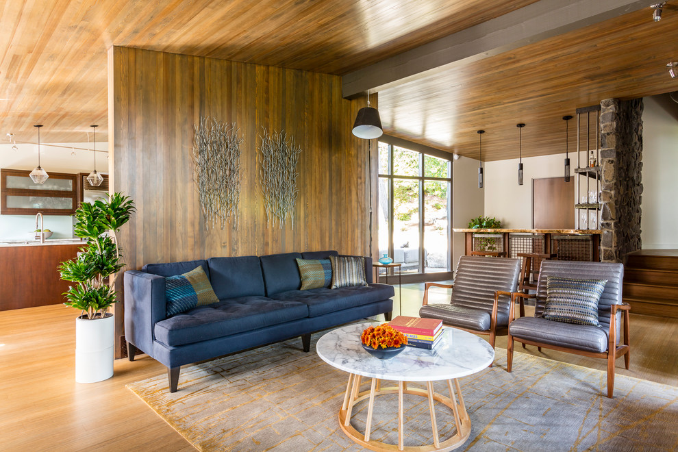 Imagen de salón abierto rústico con paredes marrones y suelo de madera en tonos medios
