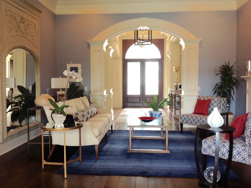 Пример оригинального дизайна: парадная, изолированная гостиная комната среднего размера в стиле неоклассика (современная классика) с синими стенами, паркетным полом среднего тона, стандартным камином, фасадом камина из камня и коричневым полом без телевизора