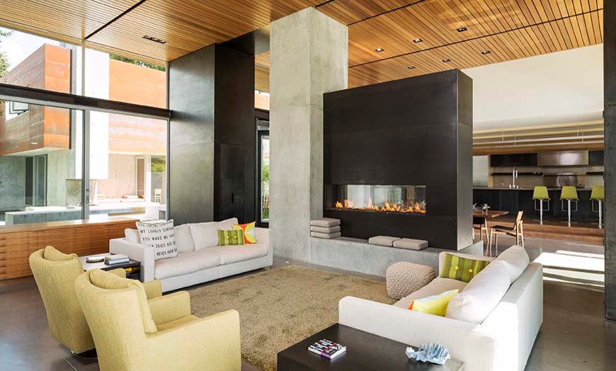 Идея дизайна: большая парадная, открытая гостиная комната в современном стиле с бетонным полом, двусторонним камином и фасадом камина из металла