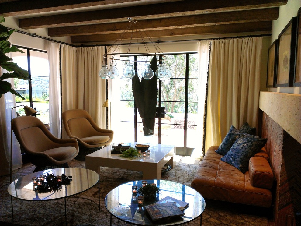 Immagine di un soggiorno mediterraneo di medie dimensioni e chiuso con pareti beige, moquette, camino classico, cornice del camino in mattoni e nessuna TV