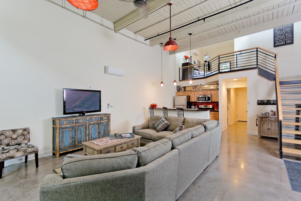 This is an example of a medium sized urban mezzanine living room in Other with white walls, concrete flooring, no fireplace and a freestanding tv.