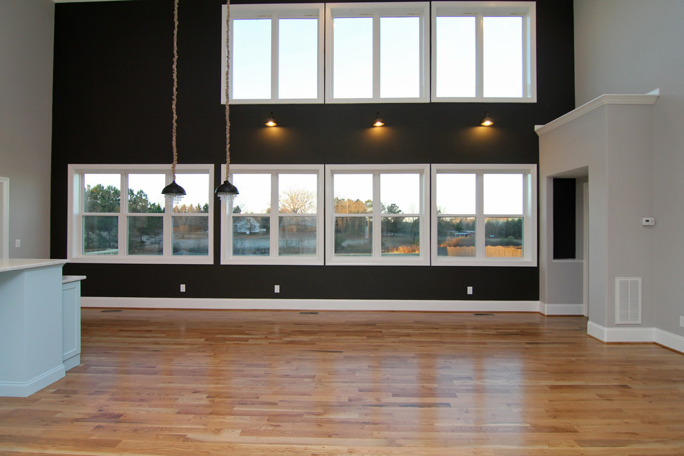 Foto på ett stort funkis allrum med öppen planlösning, med grå väggar, ljust trägolv, en standard öppen spis och en spiselkrans i tegelsten