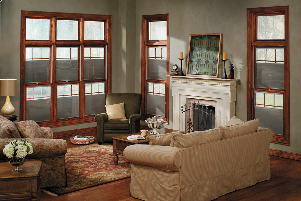 Cette image montre un salon traditionnel de taille moyenne et fermé avec une salle de réception, un mur vert et un sol en bois brun.
