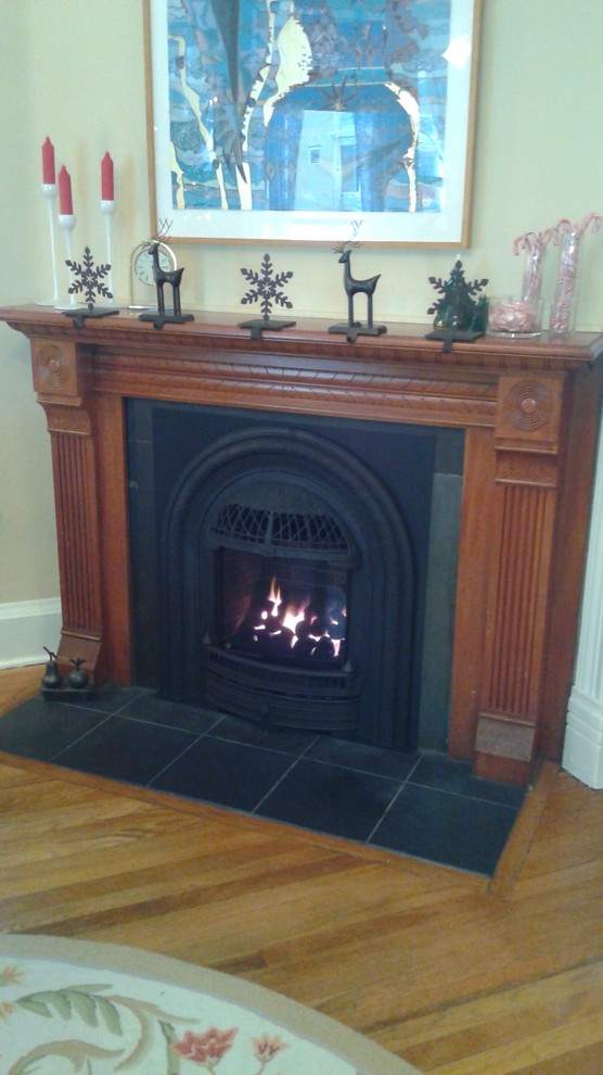 ミネアポリスにある低価格の小さなヴィクトリアン調のおしゃれなリビング (白い壁、スレートの床、標準型暖炉、金属の暖炉まわり、テレビなし) の写真