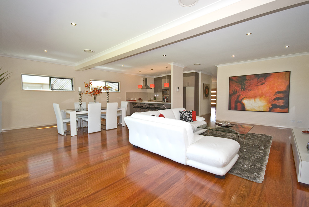 Großes, Offenes Modernes Wohnzimmer ohne Kamin mit hellem Holzboden und beiger Wandfarbe in Brisbane