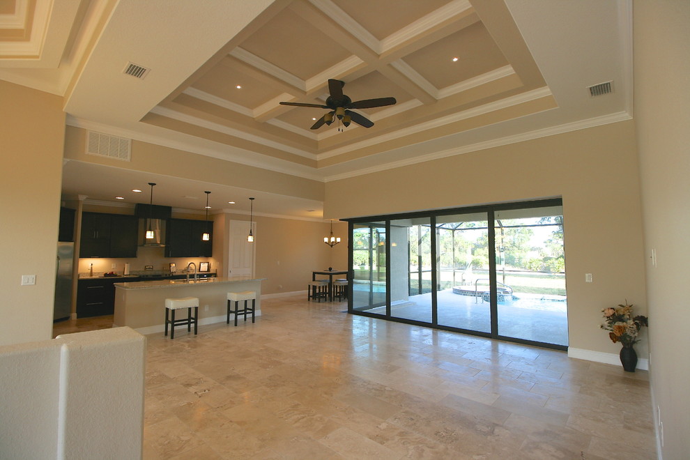 Ejemplo de salón abierto actual de tamaño medio con paredes beige y suelo de travertino
