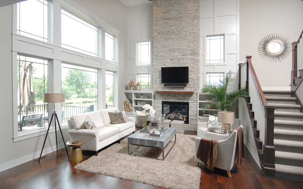 Photo of a medium sized contemporary open plan living room in Other with grey walls, dark hardwood flooring, a standard fireplace, a stone fireplace surround, a wall mounted tv and brown floors.
