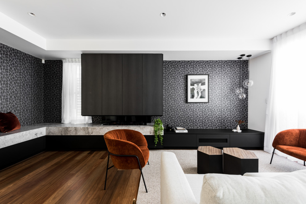 На фото: огромная гостиная комната в современном стиле с черными стенами, двусторонним камином и фасадом камина из камня с