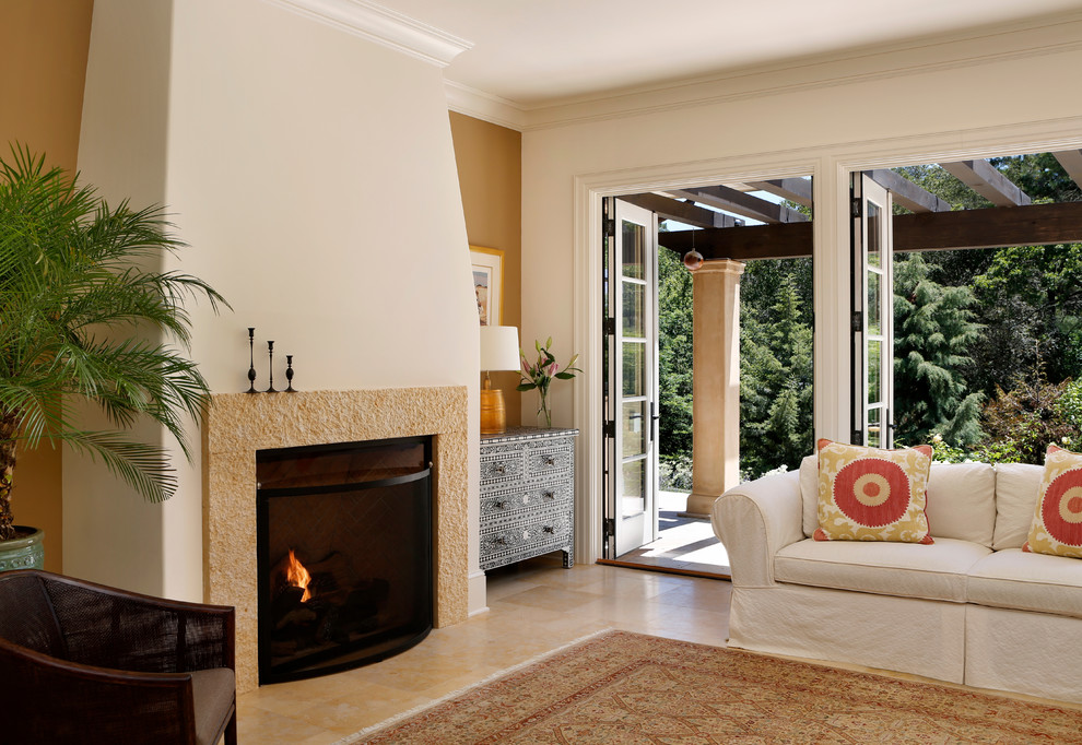 Пример оригинального дизайна: гостиная комната в средиземноморском стиле с оранжевыми стенами и стандартным камином
