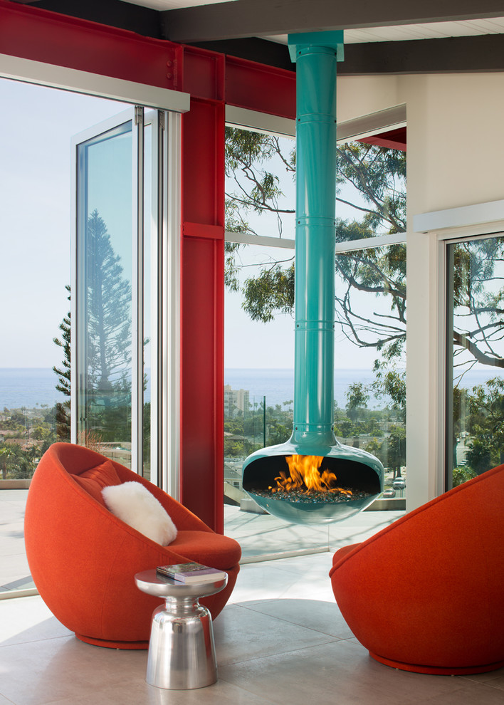 Inspiration pour un salon design ouvert avec un mur rouge, cheminée suspendue, un manteau de cheminée en métal et un sol gris.