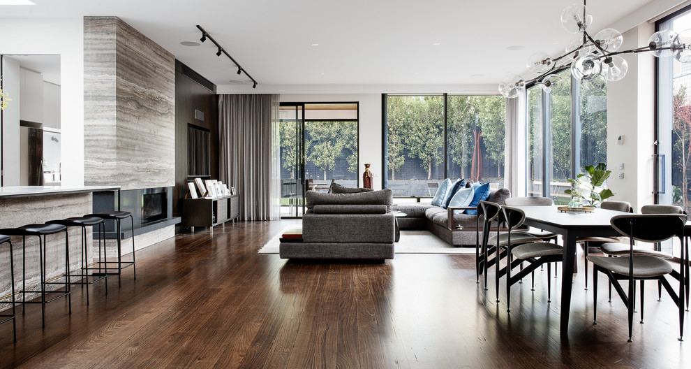 Large contemporary open plan living room in Melbourne with dark hardwood flooring, a ribbon fireplace, a stone fireplace surround and brown floors.