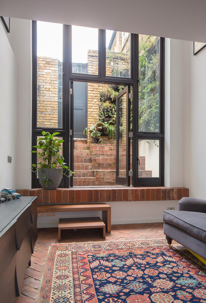Design ideas for a small urban open plan living room in London with brick flooring.