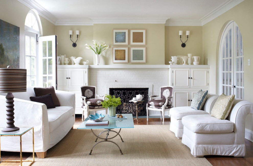 Example of a large transitional enclosed medium tone wood floor and brown floor living room design in Chicago with beige walls, a brick fireplace and a standard fireplace