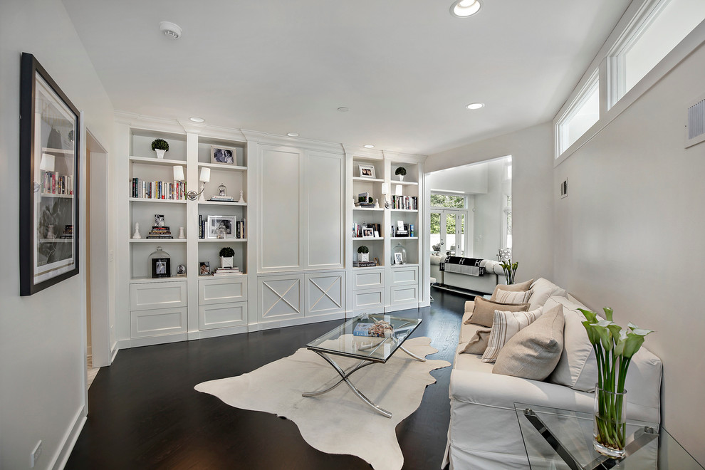 Стильный дизайн: изолированная гостиная комната в стиле неоклассика (современная классика) с белыми стенами, темным паркетным полом и скрытым телевизором - последний тренд