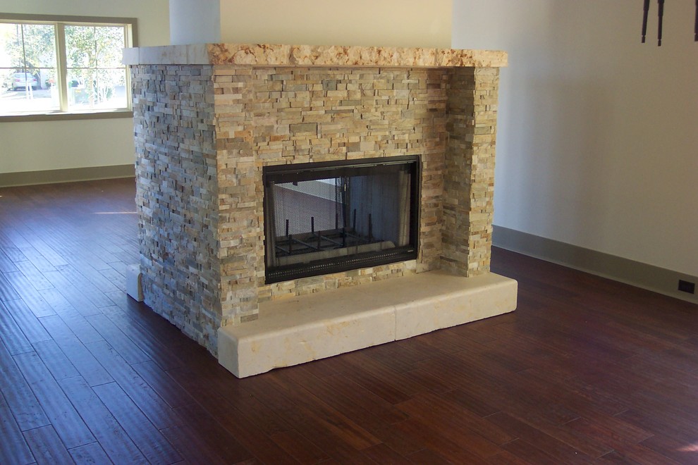 Example of a large classic open concept dark wood floor and brown floor living room design in Austin with white walls, a two-sided fireplace, a stone fireplace and no tv