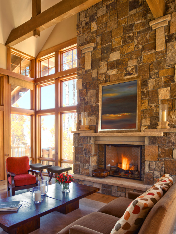 This is an example of a large modern living room in Denver with beige walls, light hardwood flooring, a standard fireplace, a stone fireplace surround, a concealed tv and brown floors.
