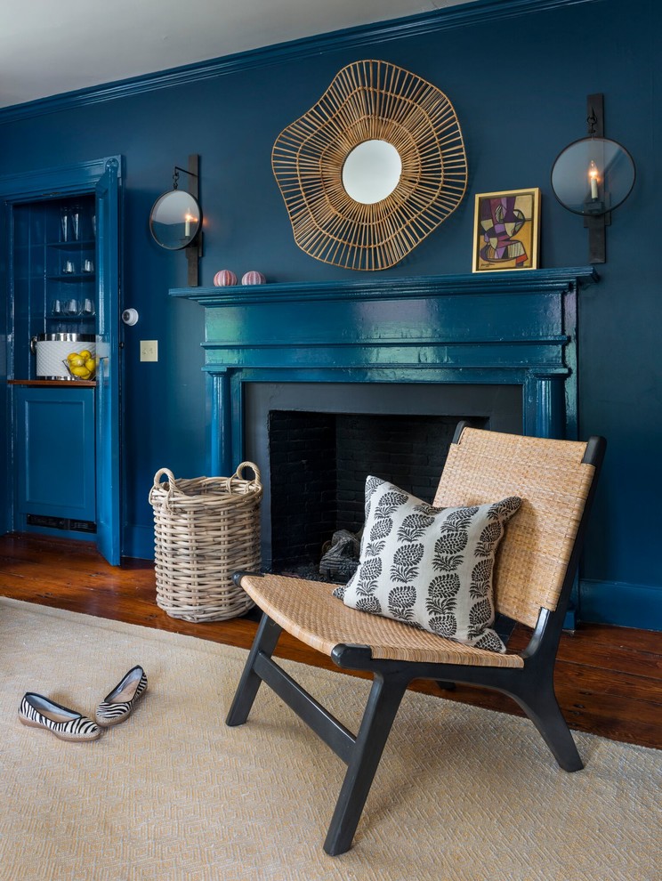 Inspiration för ett mellanstort vintage vardagsrum, med blå väggar, en standard öppen spis, en spiselkrans i gips och mellanmörkt trägolv