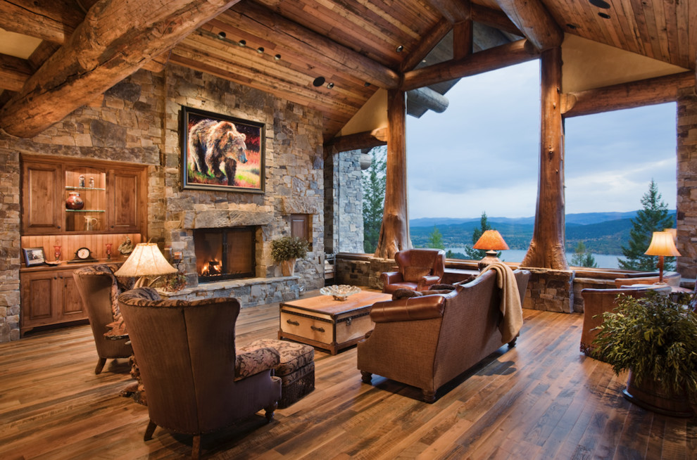 Large rustic open plan living room in Portland with beige walls, dark hardwood flooring, a standard fireplace, a stone fireplace surround and brown floors.