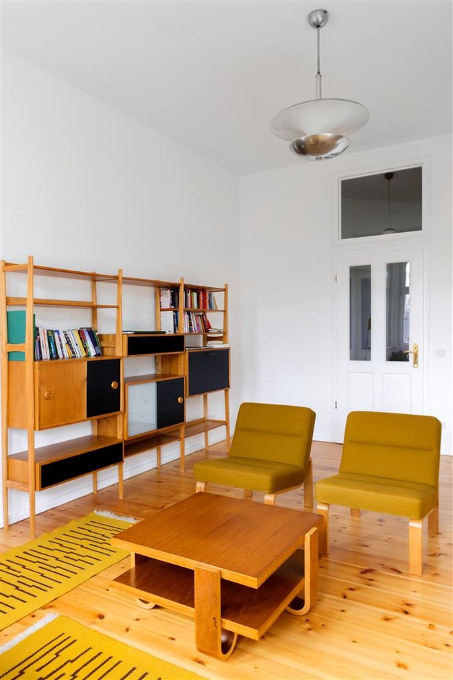 Пример оригинального дизайна: изолированная гостиная комната среднего размера в стиле ретро с с книжными шкафами и полками, белыми стенами и паркетным полом среднего тона без камина, телевизора