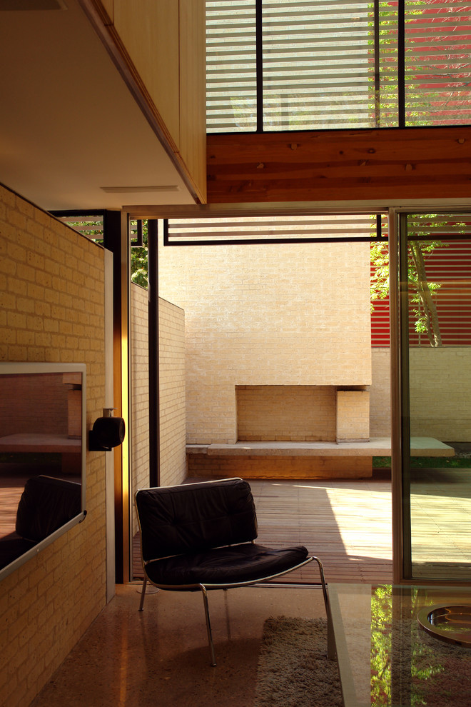 На фото: большая парадная, открытая гостиная комната в стиле модернизм с белыми стенами, бетонным полом и телевизором на стене с