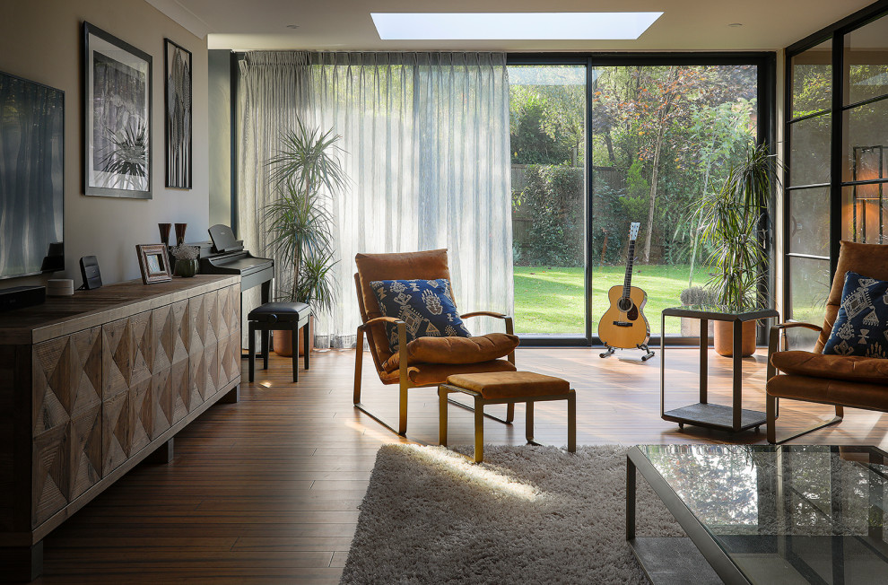 Aménagement d'un grand salon contemporain avec un mur beige, parquet en bambou, un téléviseur fixé au mur et un sol marron.