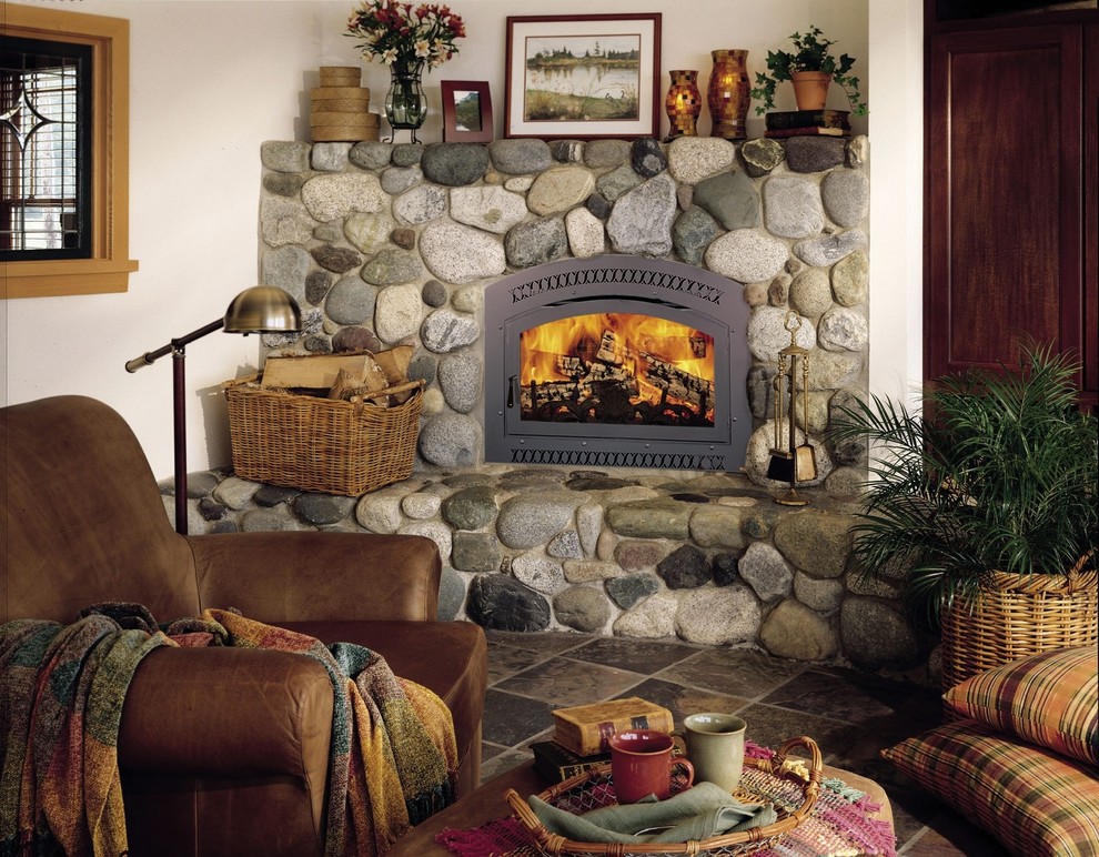 他の地域にあるお手頃価格の中くらいなトラディショナルスタイルのおしゃれなリビング (標準型暖炉、石材の暖炉まわり、スレートの床、白い壁、グレーの床) の写真