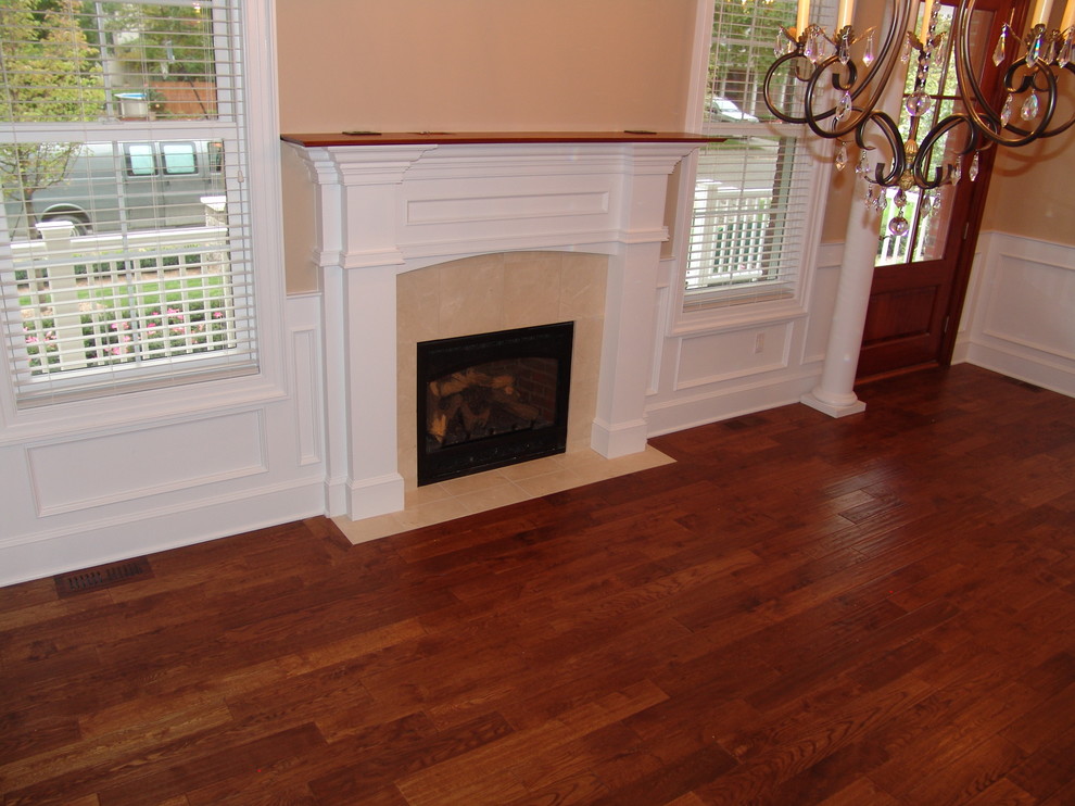Photo of a classic living room in Detroit with medium hardwood flooring, a standard fireplace and a tiled fireplace surround.