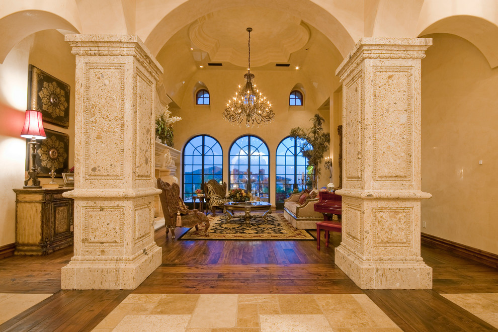 Imagen de salón para visitas abierto tradicional extra grande con paredes beige, suelo de madera en tonos medios, todas las chimeneas y marco de chimenea de piedra