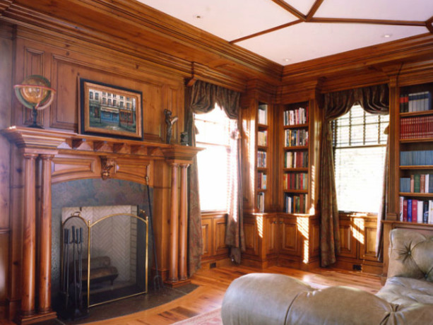 Inredning av ett klassiskt separat vardagsrum, med ett bibliotek, ljust trägolv, en standard öppen spis och bruna väggar