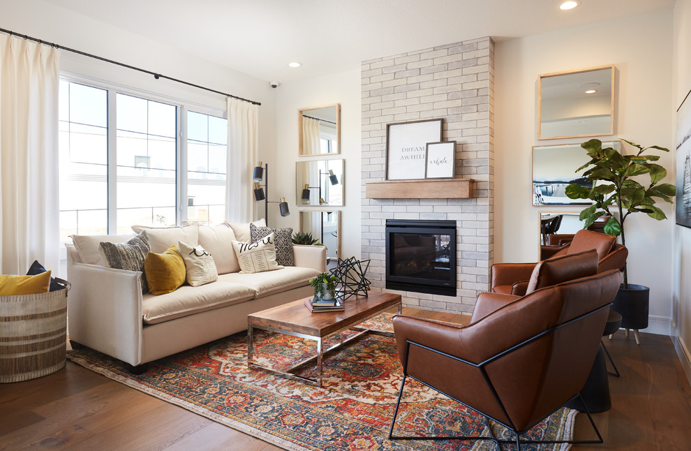 Inspiration for a mid-sized cottage open concept medium tone wood floor and brown floor living room remodel in Edmonton with white walls, a standard fireplace and a brick fireplace
