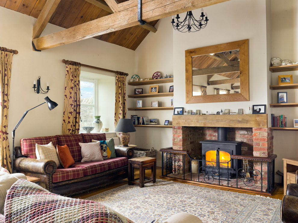 Design ideas for a medium sized traditional enclosed living room in Oxfordshire with blue walls, dark hardwood flooring, a standard fireplace, a brick fireplace surround and brown floors.