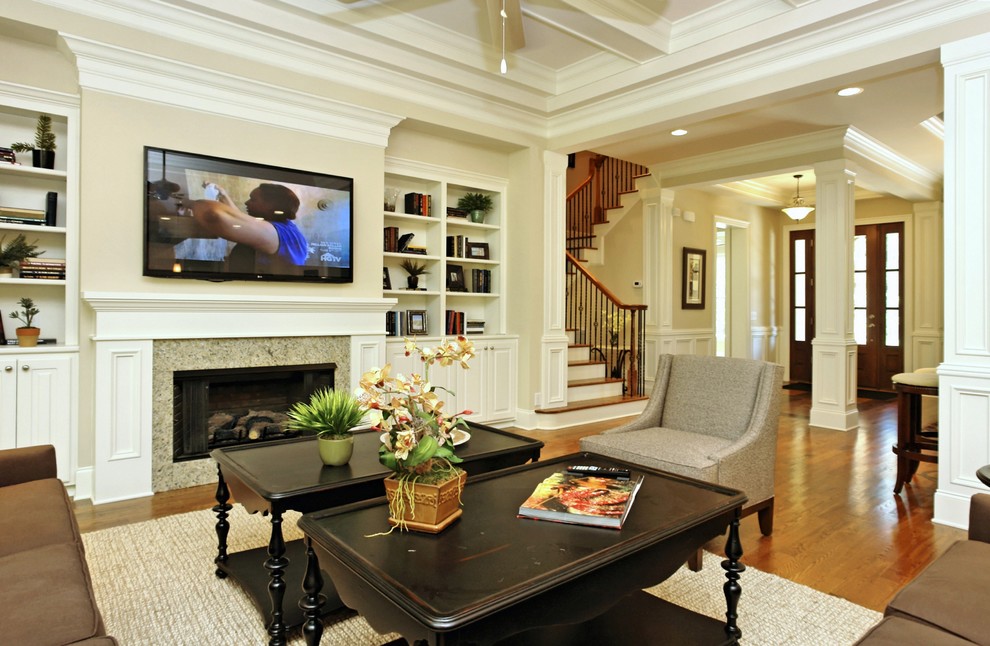 This is an example of a large classic open plan living room in Raleigh with beige walls, dark hardwood flooring, a standard fireplace, a stone fireplace surround and a wall mounted tv.