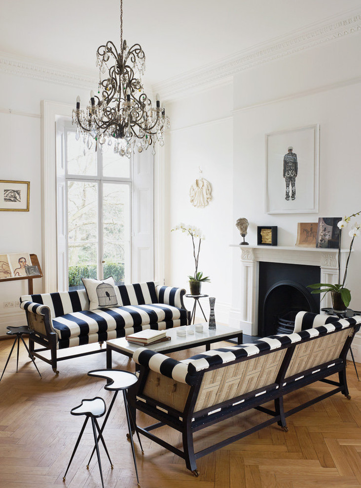 Fernseherloses Klassisches Wohnzimmer mit weißer Wandfarbe, braunem Holzboden, Kamin und Kaminumrandung aus Stein in Sonstige