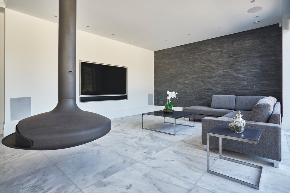 Diseño de salón actual con paredes blancas, chimeneas suspendidas, marco de chimenea de metal, pared multimedia y suelo gris