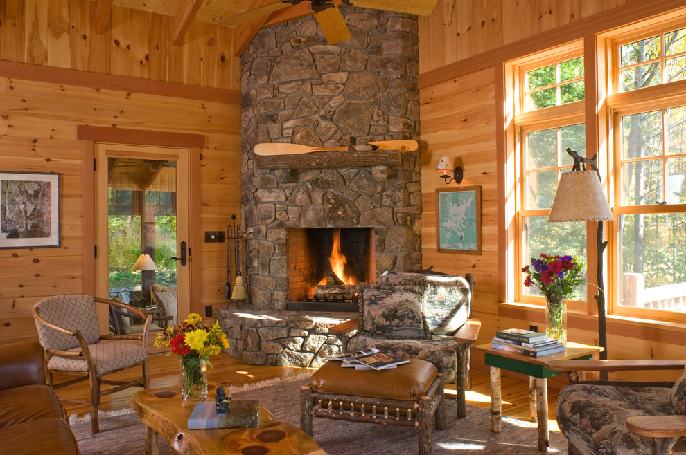 Rustic formal living room in Boston with medium hardwood flooring, a corner fireplace, a stone fireplace surround, no tv and brown walls.