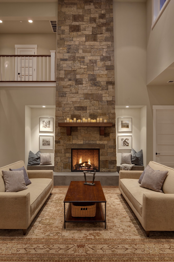На фото: гостиная комната в стиле неоклассика (современная классика) с бежевыми стенами, стандартным камином, фасадом камина из камня и ковром на полу с