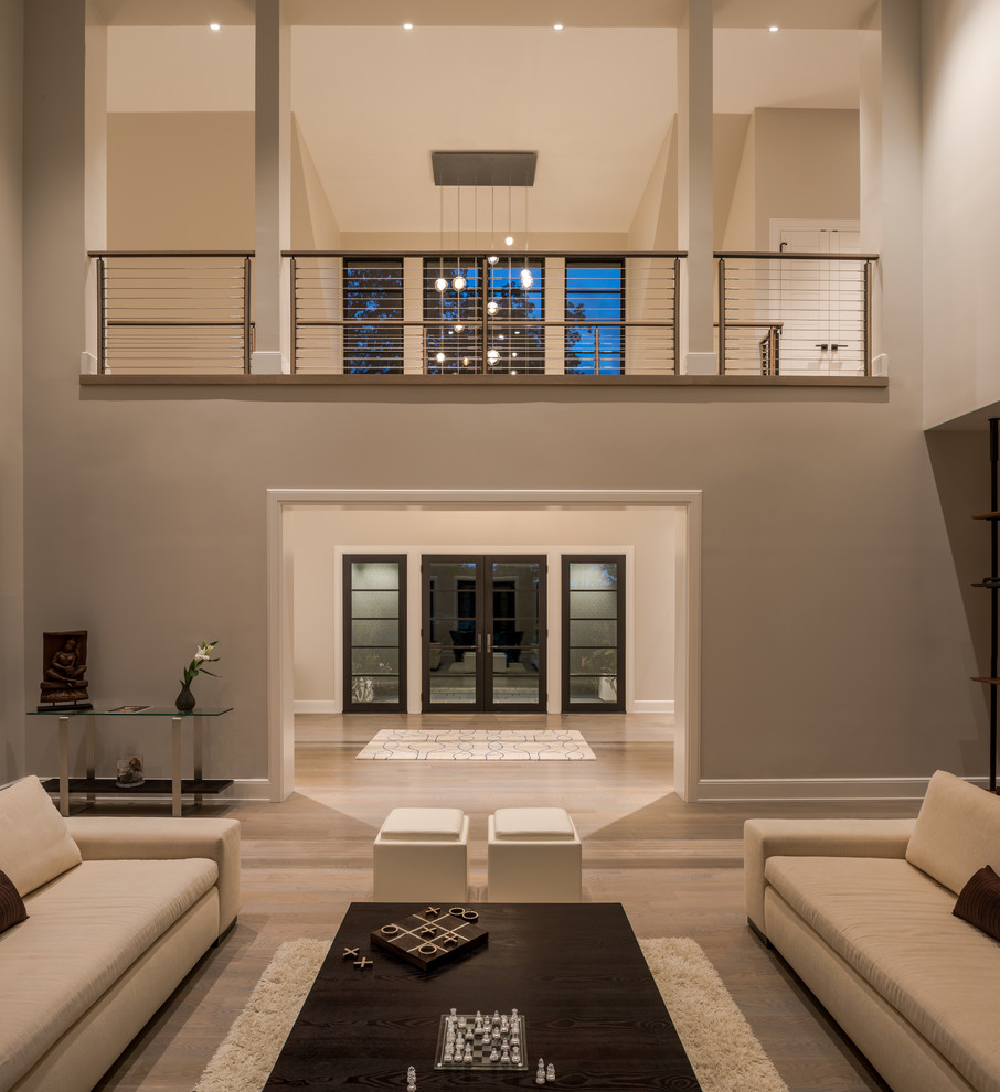 Источник вдохновения для домашнего уюта: большая открытая гостиная комната в стиле неоклассика (современная классика) с серыми стенами, светлым паркетным полом и серым полом