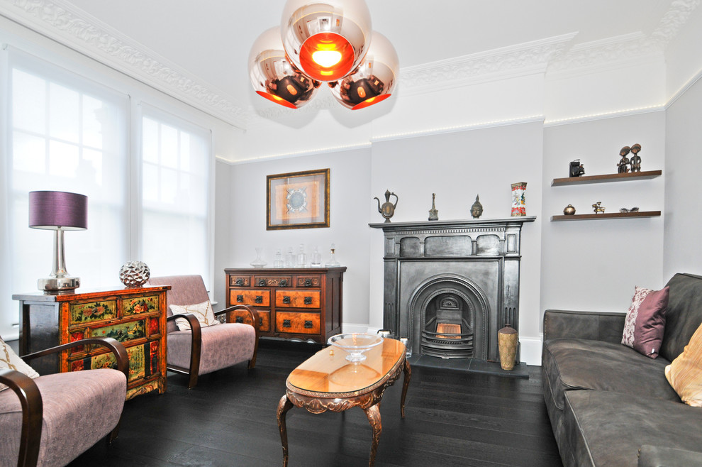 Cette image montre un salon design avec un mur gris et une cheminée standard.