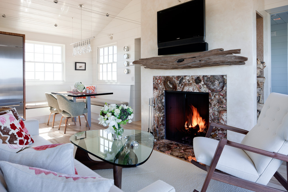 Example of a small beach style open concept light wood floor living room design in Boston with a standard fireplace, a wall-mounted tv, white walls and a stone fireplace